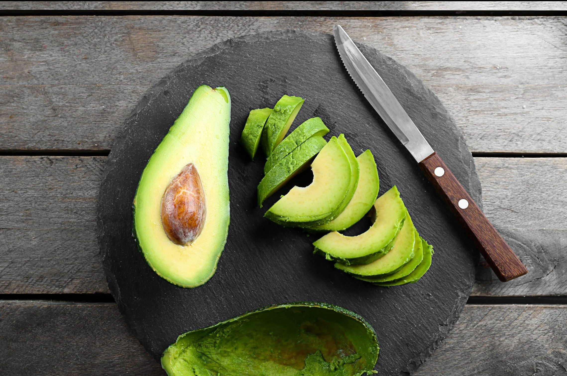 Sliced,Avocado,With,Knife,On,Slate,Plate