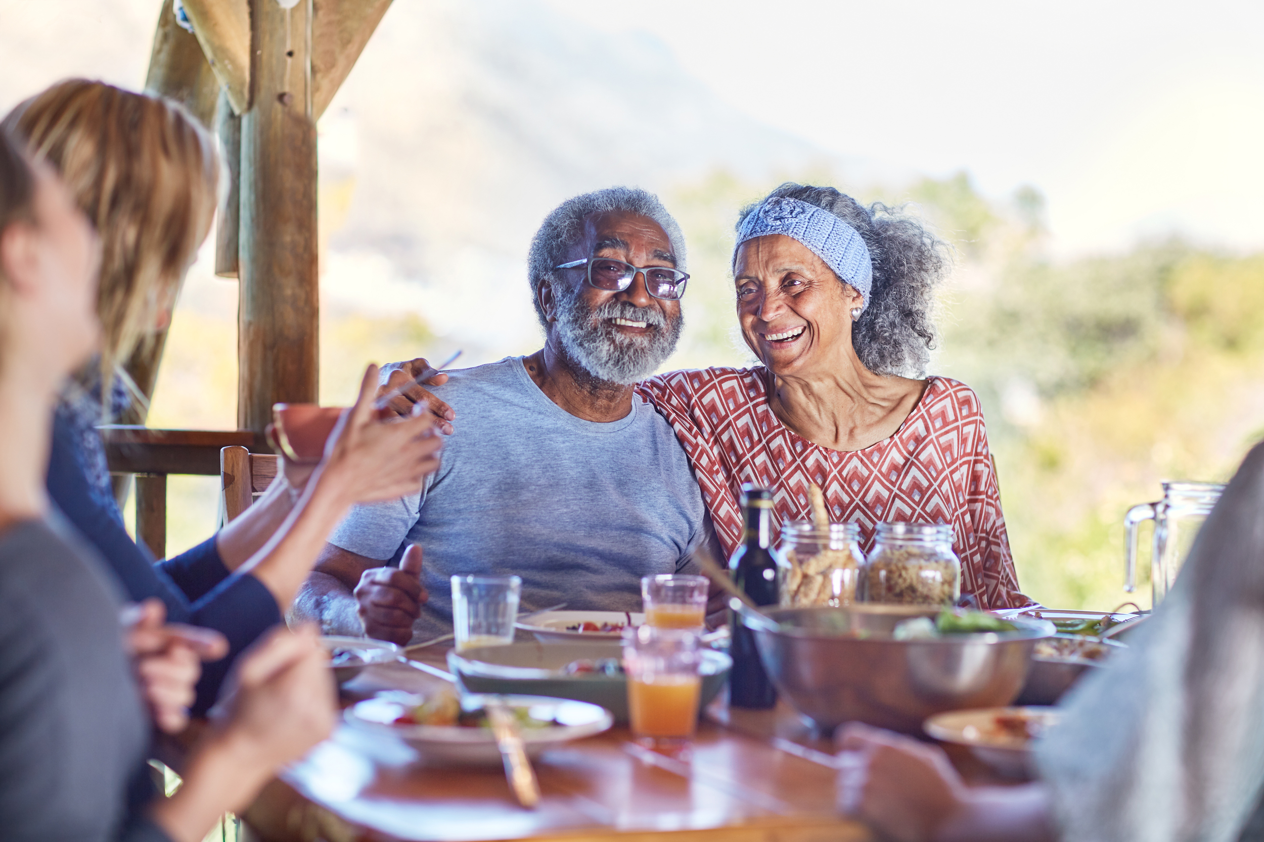 Happy senior couple enjoying healthy meal in hut during yoga retreat