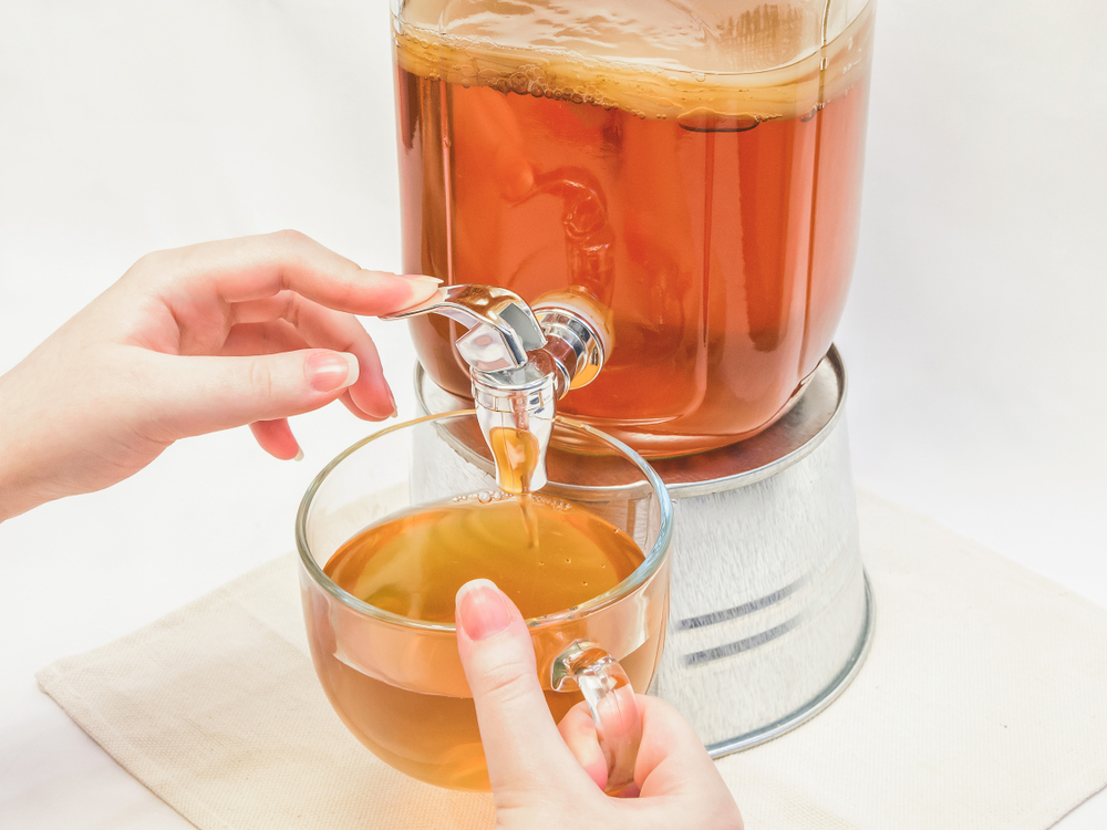 A,Woman,Pours,Homemade,Healthy,Kombucha,Tea,From,A,Jar