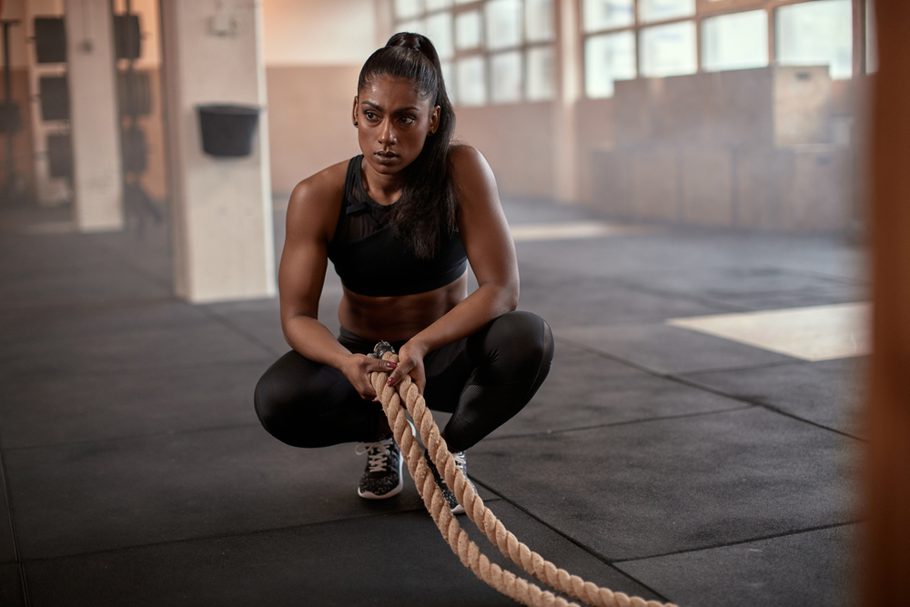 Fit,Young,Indian,Woman,In,Sportswear,Crouching,On,A,Gym