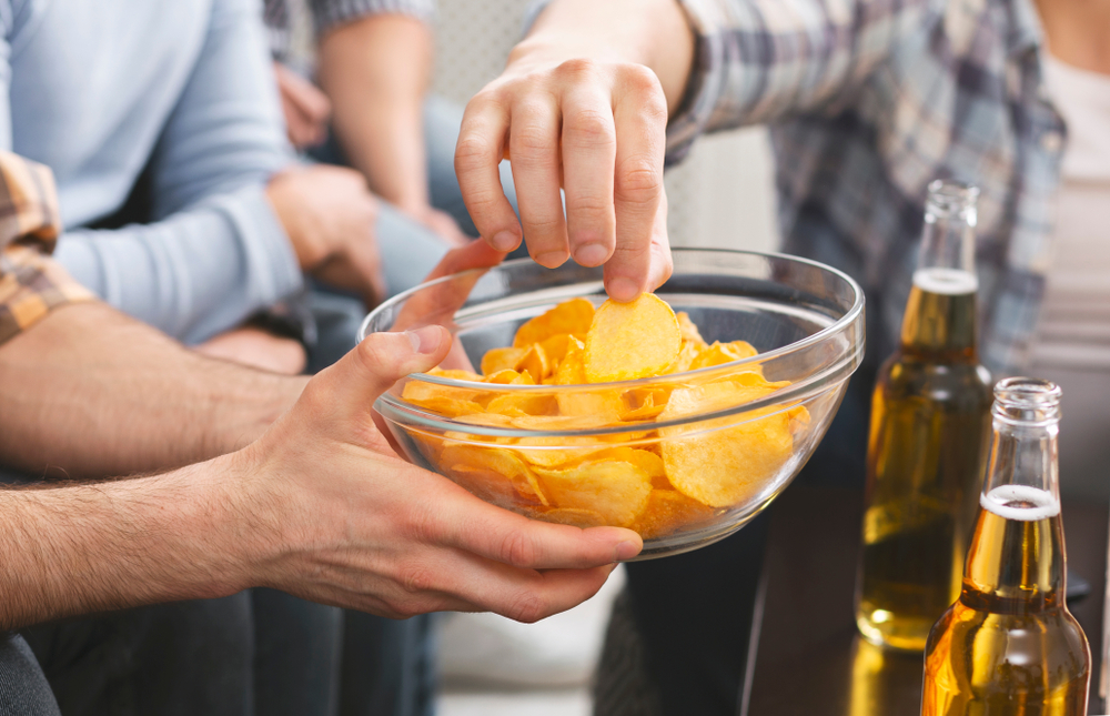 Close,Up,Of,Man,Holding,Bowl,With,Chips,Sharing,With