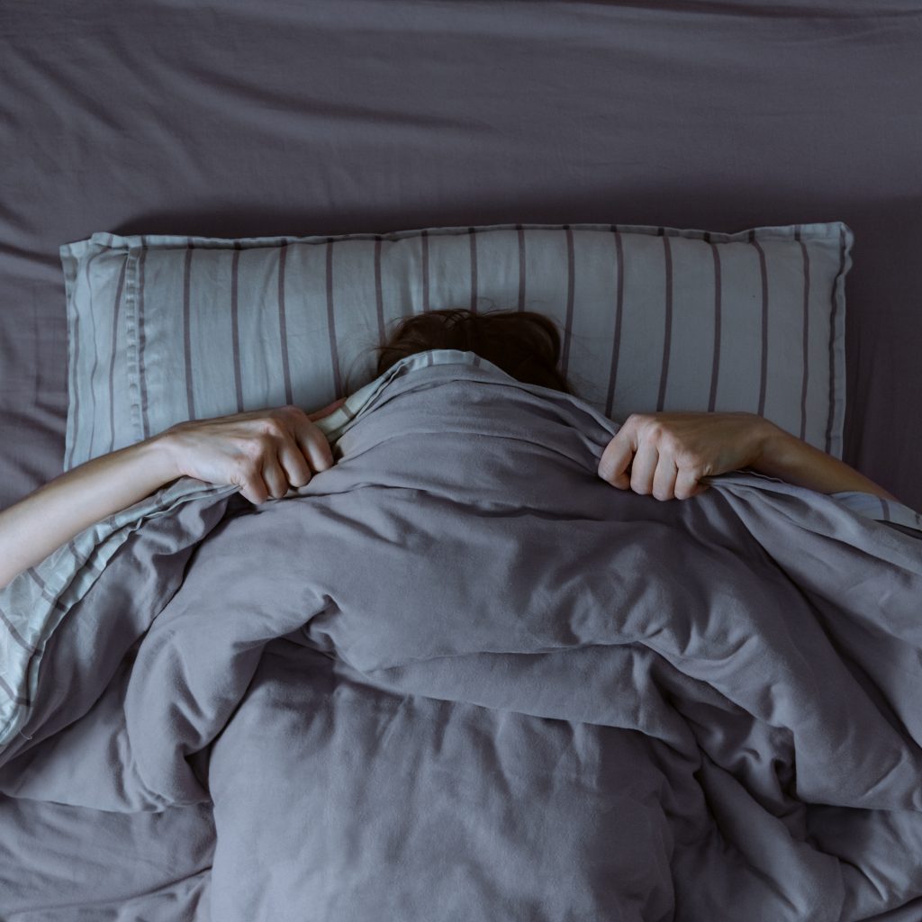 Top,View,Of,Scared,Woman,In,Bed,Covering,Her,Face