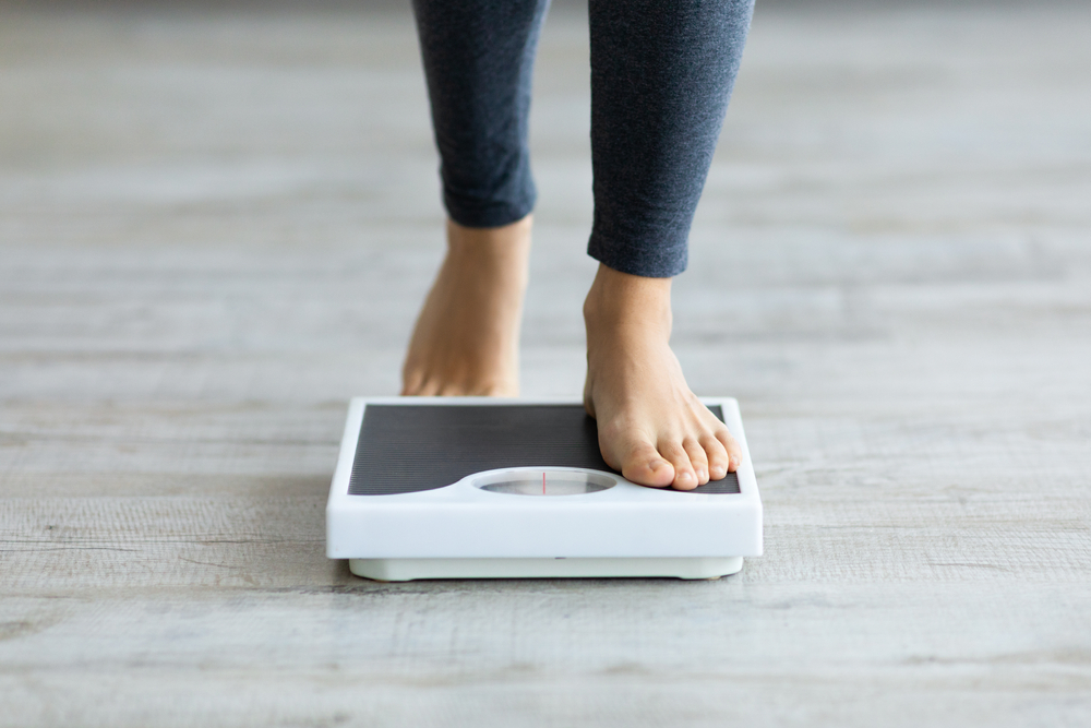 Unrecognizable,Young,Indian,Woman,Stepping,On,Scales,To,Measure,Her