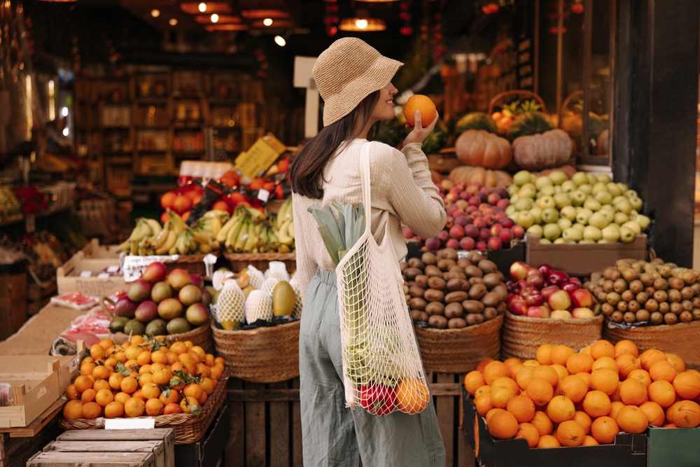 Fair-skinned,Young,Girl,Holds,Orange,Standing,With,Her,Back,To