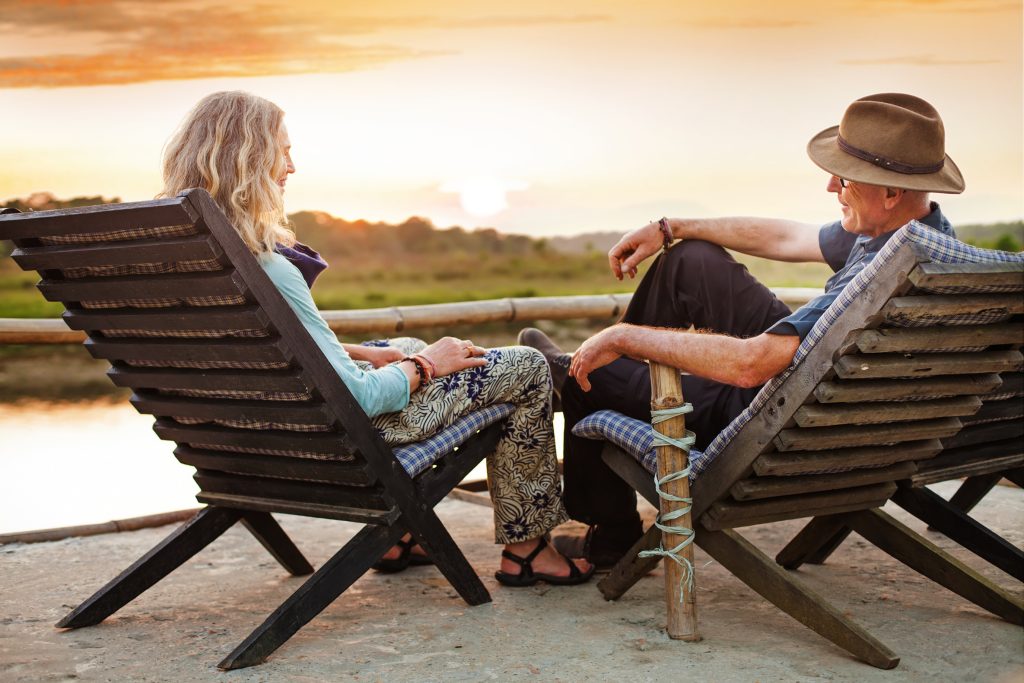 Senior,Couple,Sitting,On,Chairs,With,Their,Backs,At,The