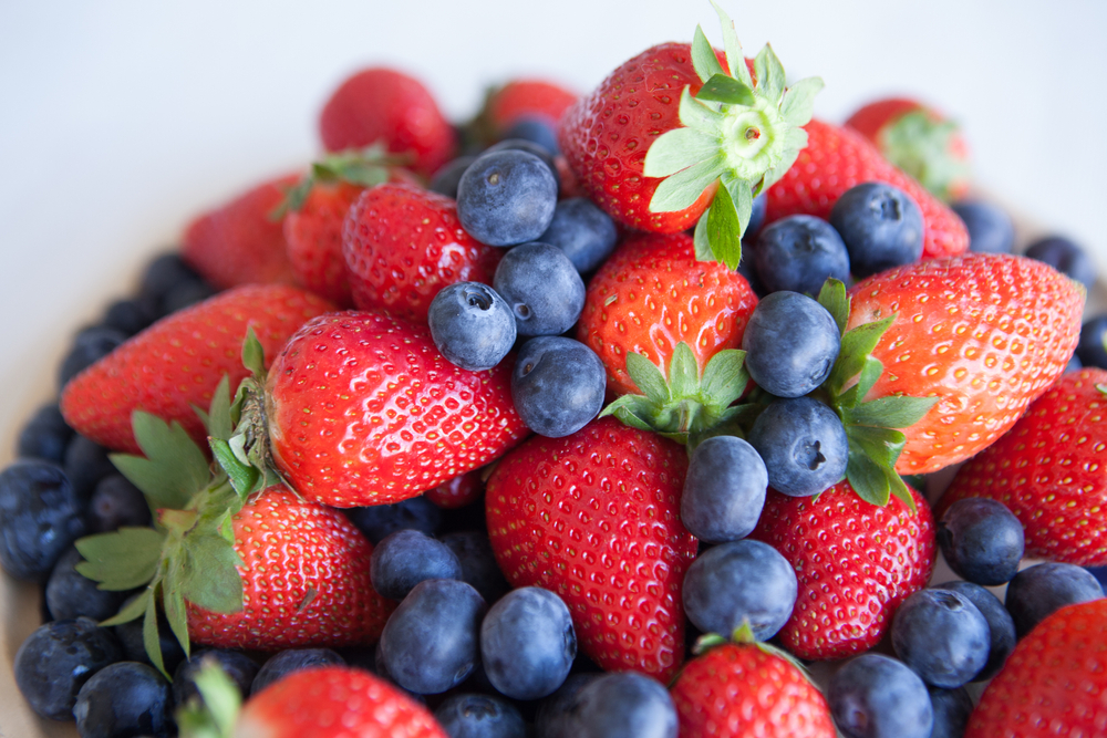 Blueberries,And,Strawberries,In,A,Ceramic,Plate,On,The,Table.