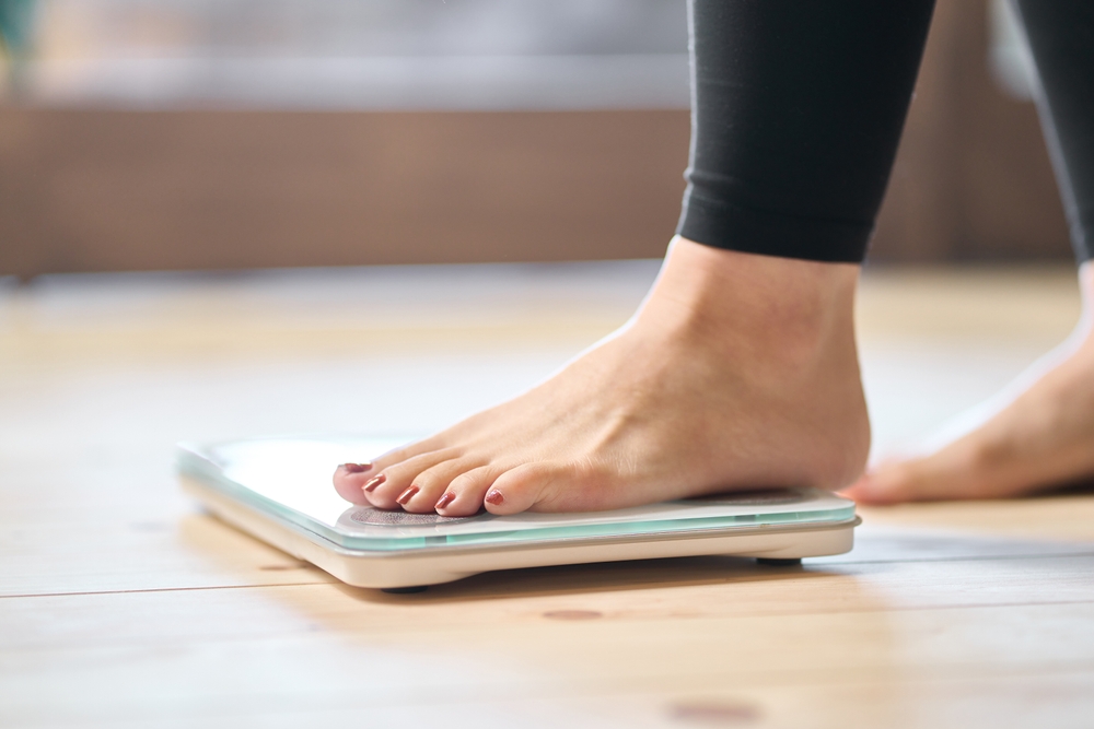 Feet,Of,An,Asian,Woman,On,A,Weight,Scale